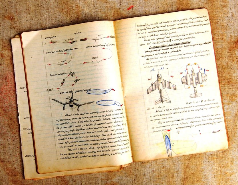 Open vintage notebook showing airplane diagrams and handwritten notes on aged paper.
